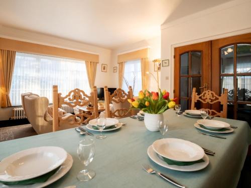 une table de salle à manger avec des assiettes et des verres dessus dans l'établissement Villa Hamarrbø with garden and parking by Interhome, au Coq