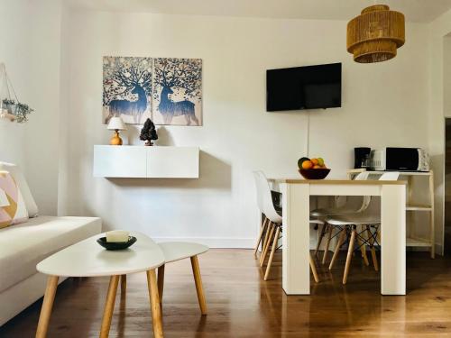 een woonkamer met een witte tafel en een witte bank bij Encantador Apartamento en Pla de l’Ermita in Pla de l'Ermita