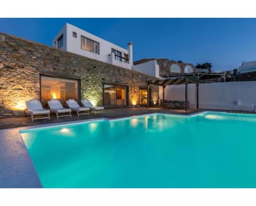 a large swimming pool in front of a house at Villa Coventina - Edge Suite in Agios Ioannis Mykonos