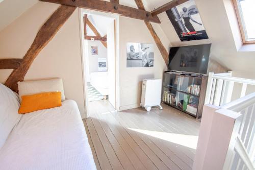 ein Wohnzimmer mit einem Bett und einem TV in der Unterkunft The Amboisian getaway - Small house for 2 people. in Amboise