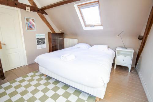 1 dormitorio con cama blanca y suelo a cuadros en The Amboisian getaway - Small house for 2 people., en Amboise