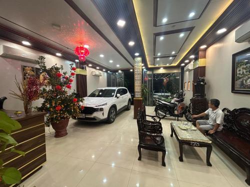 un hombre sentado en una sala de estar con un coche en Đức Lộc 2 Hotel, en Hue