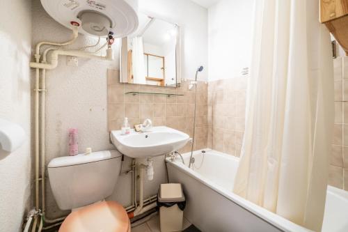 een badkamer met een wastafel, een toilet en een bad bij Residence Les Montagnes - 6 pers in Bellevaux