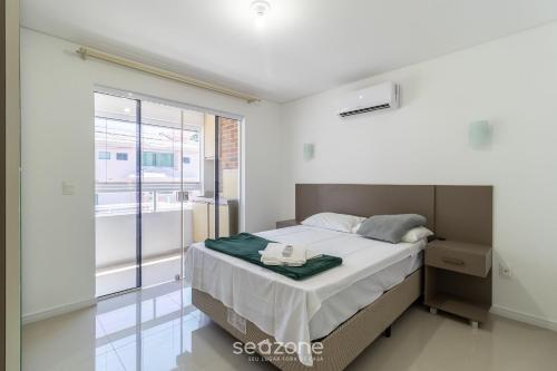 1 dormitorio con cama y ventana grande en Confortável apto em Balneário Camboriú BFH0101, en Balneário Camboriú