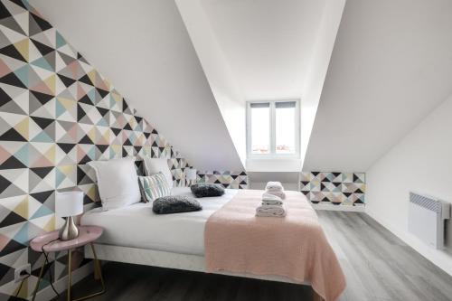 a bedroom with a large bed with a geometric headboard at 805 Suite Amazing - Superbe Duplex in Bagnolet