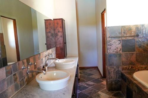 a bathroom with two sinks and a shower at Lucca House in Musina