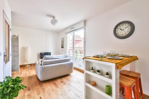 un salon avec un canapé et une horloge au mur dans l'établissement Budget studio- The river seine, à Saint-Denis