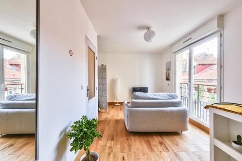 een woonkamer met 2 bedden en een bank bij Budget studio with parking - The river seine in Saint-Denis
