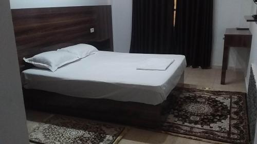 a bed with white sheets and pillows in a room at hotel amilcar tataouine in Tataouine