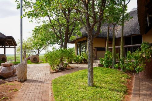 a house with a brick walkway next to a building at Lucca Lodge in Musina