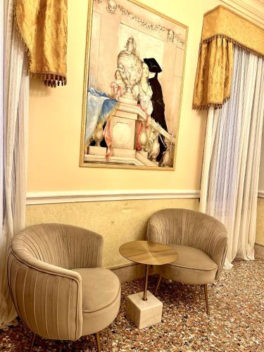 a living room with two chairs and a painting at Casa Alla Fenice in Venice