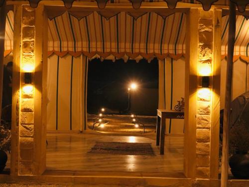 an open door with a view of a street at night at Venture Desert Camp Jaisalmer in Jaisalmer