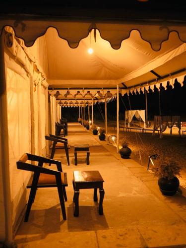 a row of benches sitting inside of a tent at Venture Desert Camp Jaisalmer in Jaisalmer