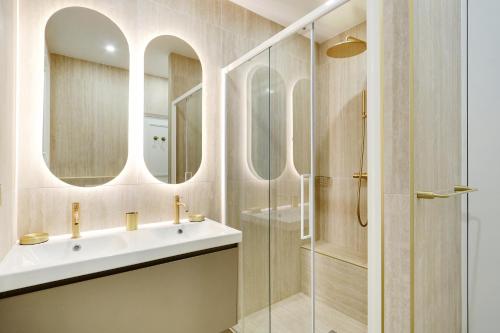 une salle de bain avec un lavabo et une douche en verre dans l'établissement Pick A Flat's Apartments in Opéra Saint Lazarre - Rue de l'Isly, à Paris
