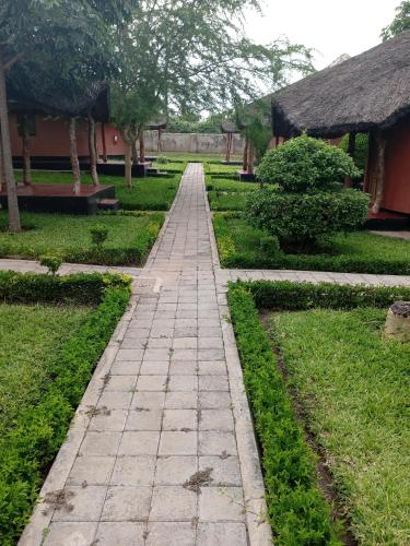 un camino de piedra en un jardín con un edificio en Kamutamba guesthouse en Masaiti