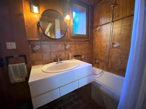 een badkamer met een wastafel, een spiegel en een bad bij Appartement Samoëns, 2 pièces, 5 personnes - FR-1-624-45 in Samoëns