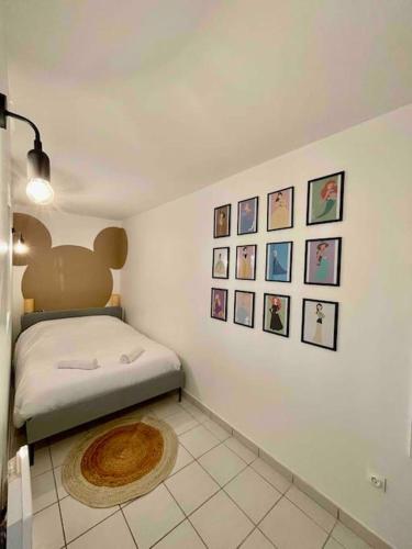 une chambre avec un lit et des tableaux au mur dans l'établissement Mickey's house - Apartments 4 persons - 10 min Disneyland Paris, à Bussy-Saint-Georges