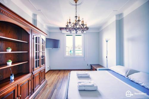 Un dormitorio con una cama grande y una lámpara de araña. en [Elegant Apartment]-con Free Wi-Fi & A/C, en San Remo