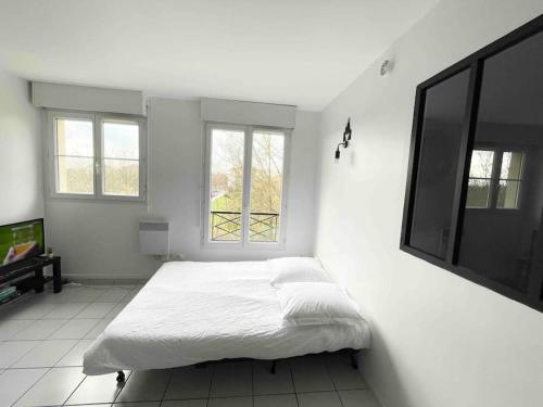 a bedroom with a bed and a flat screen tv at Mickey's house - Apartments 4 persons - 10 min Disneyland Paris in Bussy-Saint-Georges