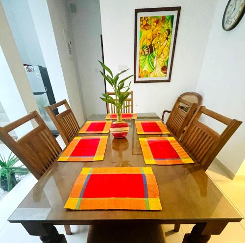 a dining room table with four chairs and a table at OESIS - Stylish Holiday Home in the heart of Galle in Galle