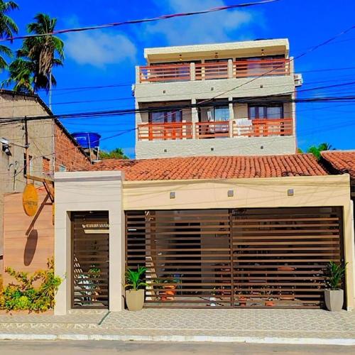 a building with two garage doors in front of it at Japaratinga Suites in Japaratinga