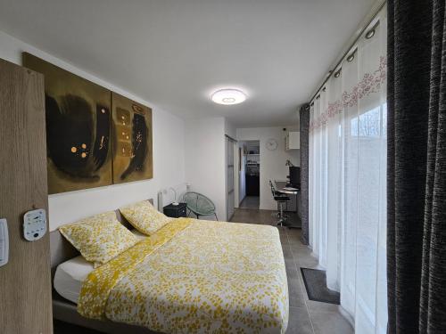 a bedroom with a bed with a yellow blanket at Résidence Studiomymy / Korea Sarangbang in Lorient