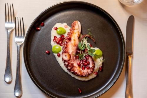 a plate of food with a piece of fish and vegetables at Hotel Nordik Adults Only - Over 14 in Andalo