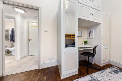 a dressing room with a mirror and a desk at Cozy Apartment in Bayswater in London