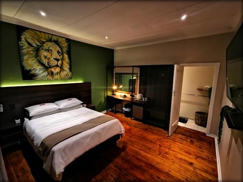 1 dormitorio con 1 cama con una pintura de león en la pared en Cozy Manor Guestrooms, en Lyttelton