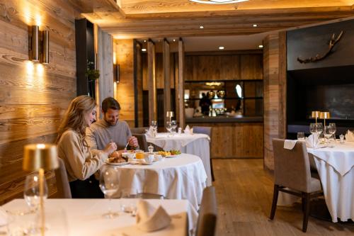 a man and woman sitting at a table in a restaurant at Hotel Nordik Adults Only - Over 14 in Andalo