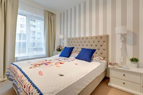 a bedroom with a large bed with blue pillows at Seaside Apartments Baltica Tower with Gym, Sauna & Parking in Gdańsk