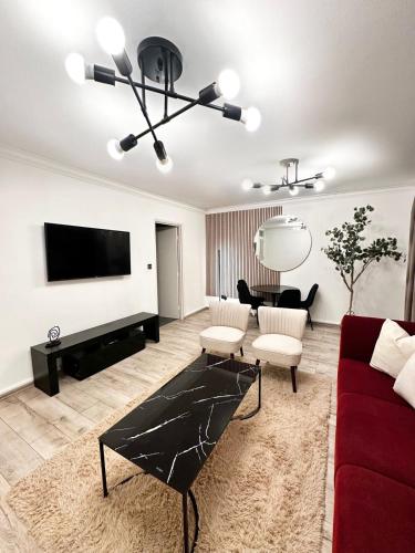 a living room with a red couch and a flat screen tv at Luxury Apartment in Central London - 24 7 Security in London