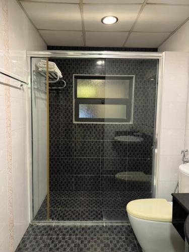 a shower with a glass door in a bathroom at Amfas Suites اجنحة امفاس in Manama