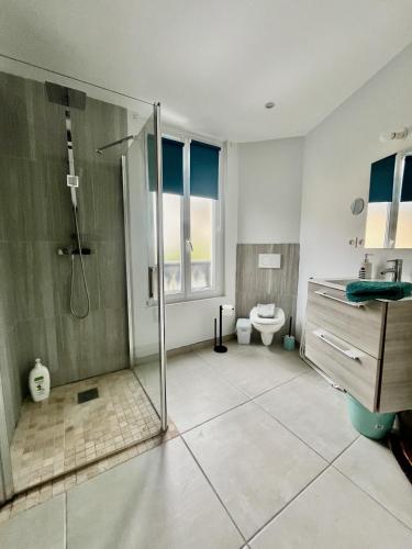 une salle de bain avec douche et toilettes dans l'établissement La Villa l'Oiseau Bleu proche de la plage et de Deauville !!! Awards 2025, à Blonville-sur-Mer