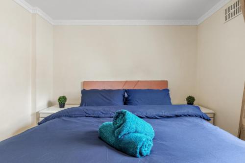 a bed with a blue towel on top of it at Cozy Apartment in Bayswater in London