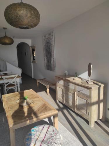 a living room with a table and a wooden cabinet at L'AUNISA in El Campello