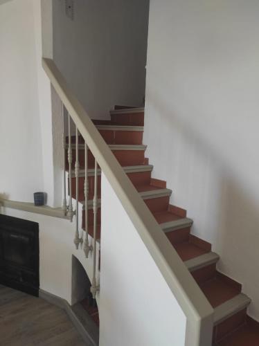 a stairway with brown and white stairs and a fireplace at L'AUNISA in El Campello