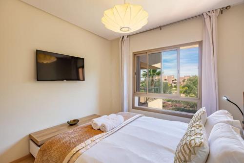 una camera con un letto e una grande finestra di Golf Prestigia, grande piscine, jardins a Marrakech