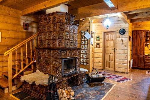a living room with a fireplace in a log cabin at Chalupa Lenka in Vysoké Tatry