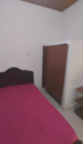 a bedroom with a purple bed with a brown door at Apto-studio en renta amoblado in Neiva