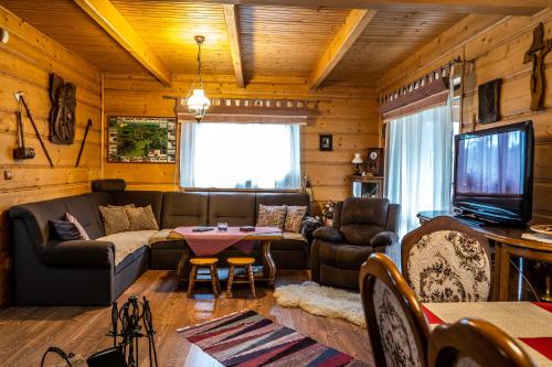 a living room with a couch and a television at Chalupa Lenka in Vysoké Tatry