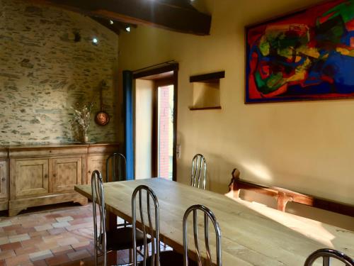 une salle à manger avec une table et des chaises en bois dans l'établissement Gîte écoresponsable avec 4 chambres, terrasse et activités, proche LPO, chauffage au sol - FR-1-426-486, à La Tardière