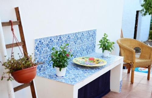 a table with a plate and potted plants on it at Violisa Charme in Castellammare del Golfo
