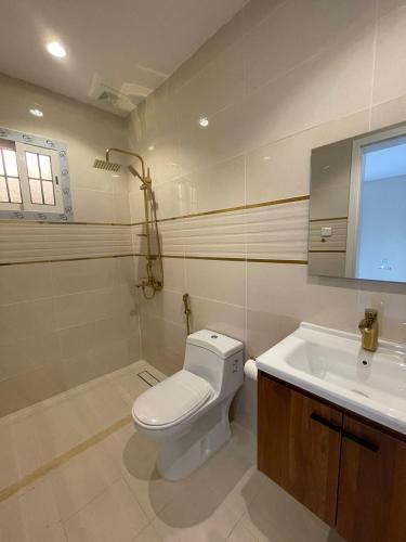 a bathroom with a toilet and a sink at استديوهات فاخرة in Ḑubā