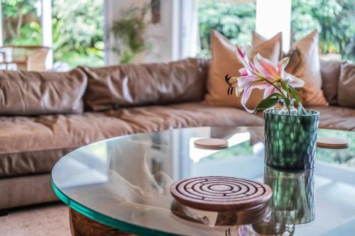 a glass coffee table with a vase of flowers on it at Luxury Private Beach Villa centrally located. in Westbrook