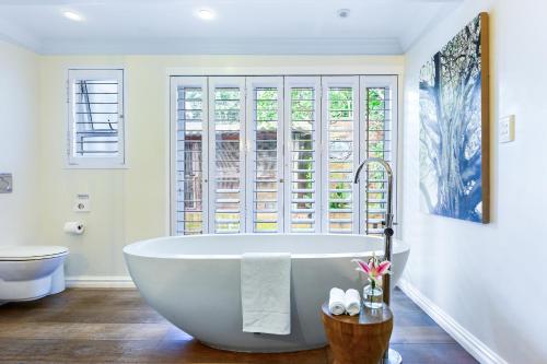 a white bath tub in a bathroom with a window at Luxury Private Beach Villa centrally located. in Westbrook
