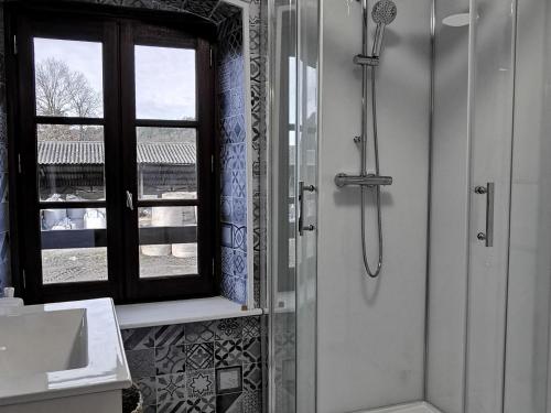 a bathroom with a shower with a window and a sink at Maison de Charme à Domeyrat: Jardin, Balades, Confort et Animations Culturelles - FR-1-582-334 in Domeyrat