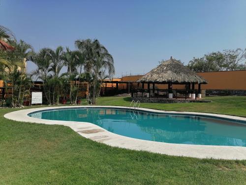 - une piscine avec gazon dans l'établissement VILLAS del SEMINARIO CERCA DE ALBERCA OLIMPICA Y TEC DE MONTERREY CUERNAVACA, à Tezoyuca