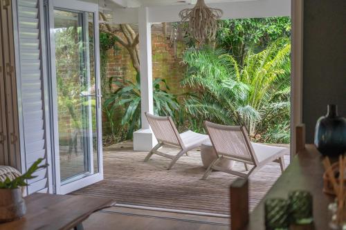a porch with two chairs and a sliding glass door at Luxury Private Beach Villa centrally located. in Westbrook