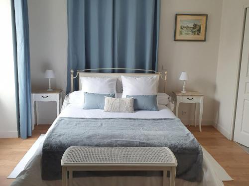 1 dormitorio con 1 cama grande y cortinas azules en Gîte Beaulieu-sur-Loire, 6 pièces, 10 personnes - FR-1-590-240, en Beaulieu-sur-Loire